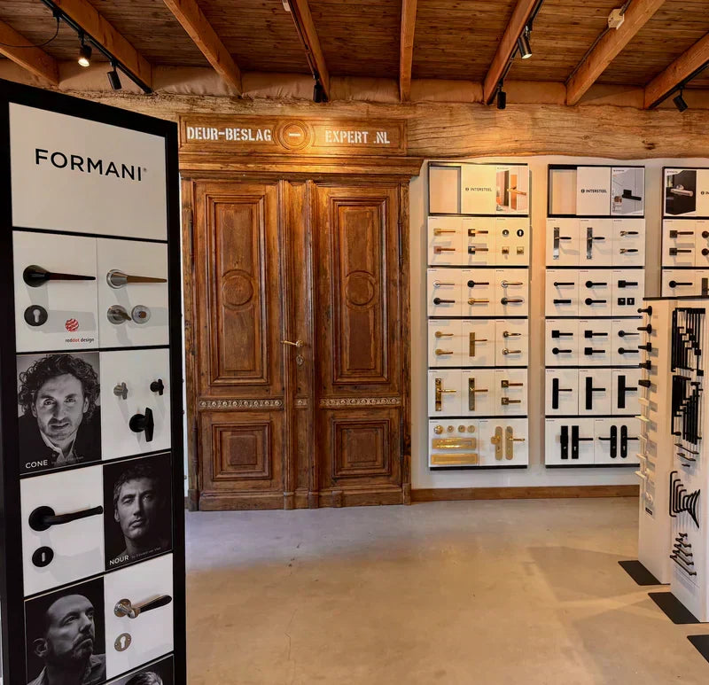 Deurbeslag trends 2026 met deurkrukken in mat zwart, brons, rvs en gun metal in de showroom