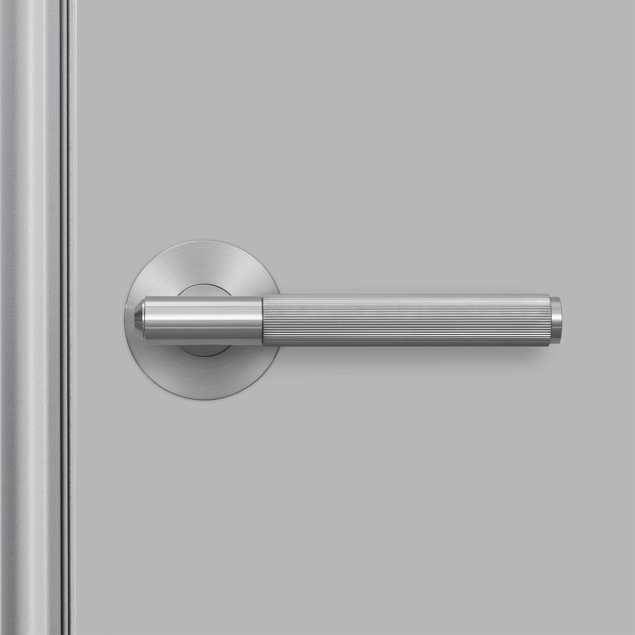 Buster + Punch Linear deurkruk op rozet in steel, gemonteerd op deur