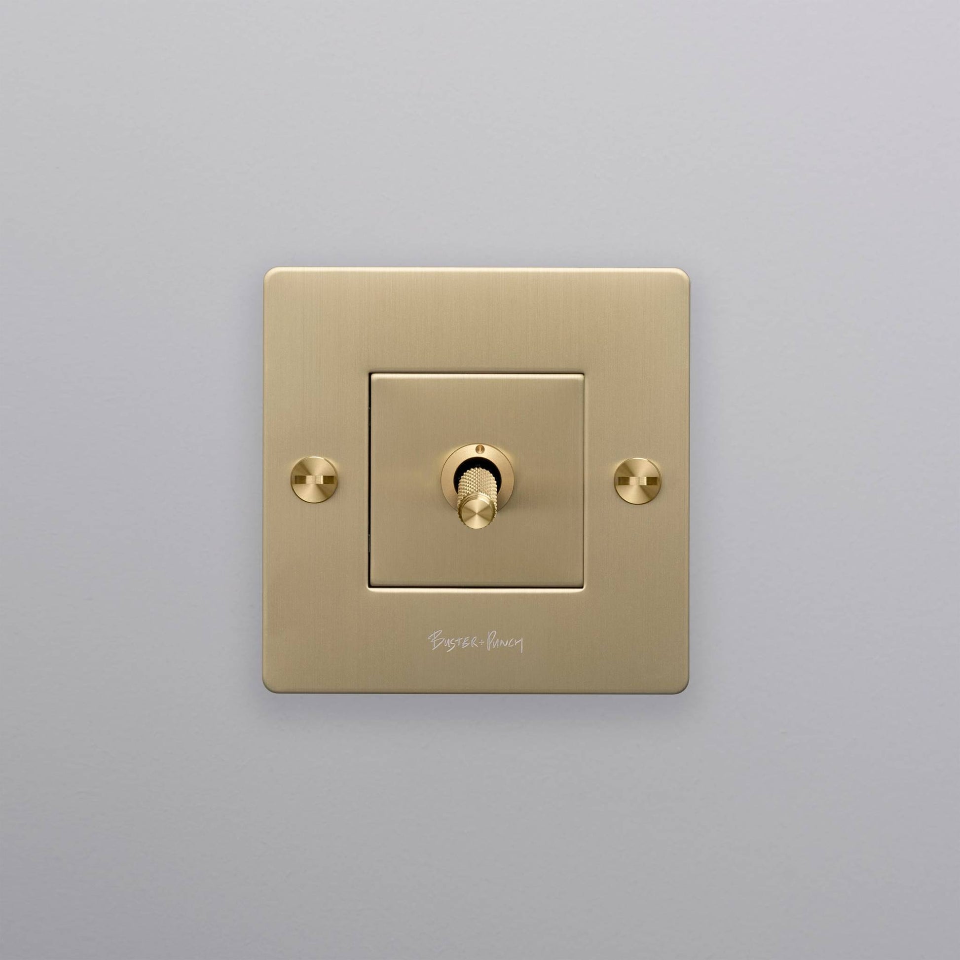 buster + punch | lichtschakelaar 1-voudige tuimelschakelaar cross (met logo) | goud zijaanzicht