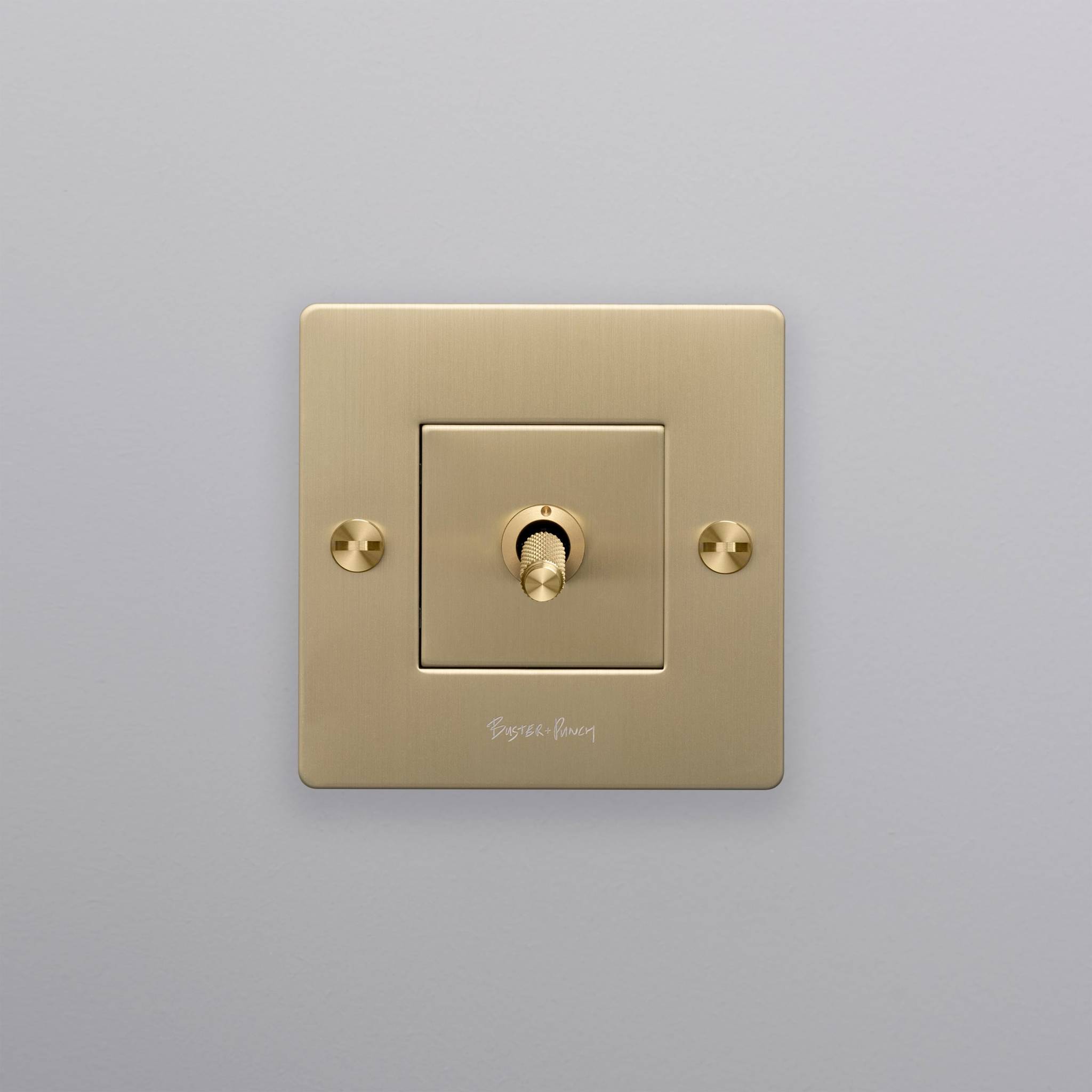 buster + punch | lichtschakelaar 1-voudige tuimelschakelaar cross (met logo) | goud zijaanzicht