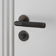 buster + punch cross | deurkruk met wc-/thumbturnslot (swe 27mm) | smoked bronze
